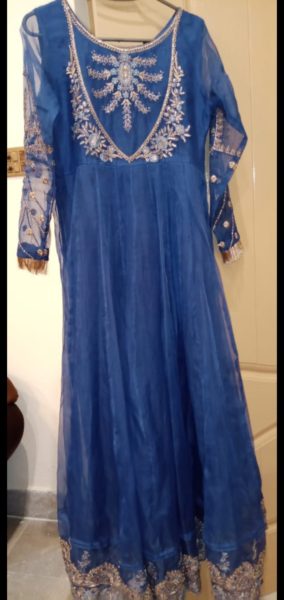 A bright blue, branded, preloved dress. Its a maxi dress with tilla and gota work.